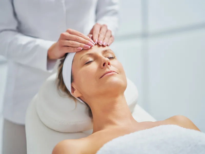 Woman receiving a relaxing facial massage at dermatology clinic